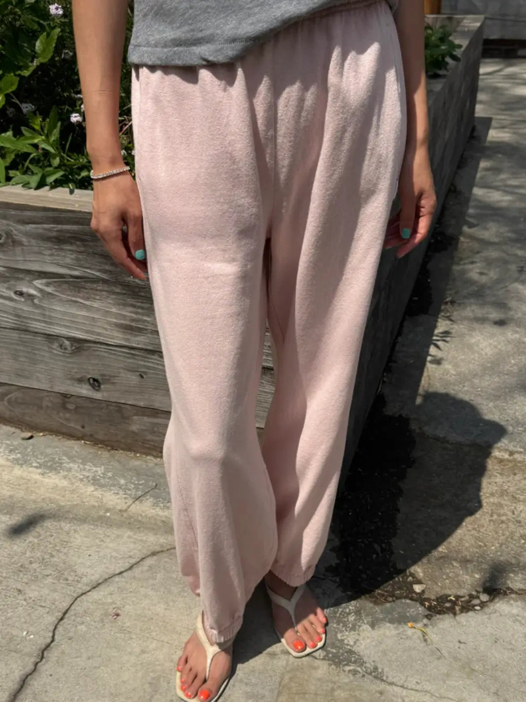 A person models the high-waisted, relaxed-fit Le Bon Shoppe Balloon Pants in Baby Pink with an elastic waistband and cuffs while standing outdoors | Twentyseven Toronto