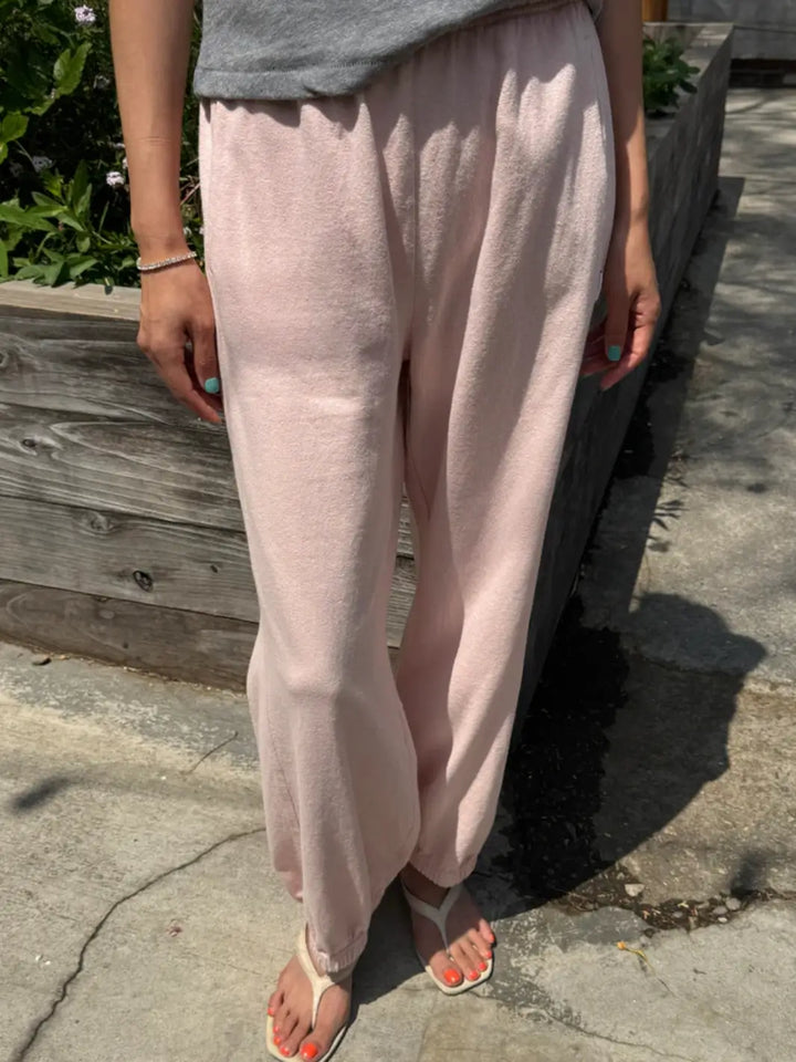 A person models the high-waisted, relaxed-fit Le Bon Shoppe Balloon Pants in Baby Pink with an elastic waistband and cuffs while standing outdoors | Twentyseven Toronto