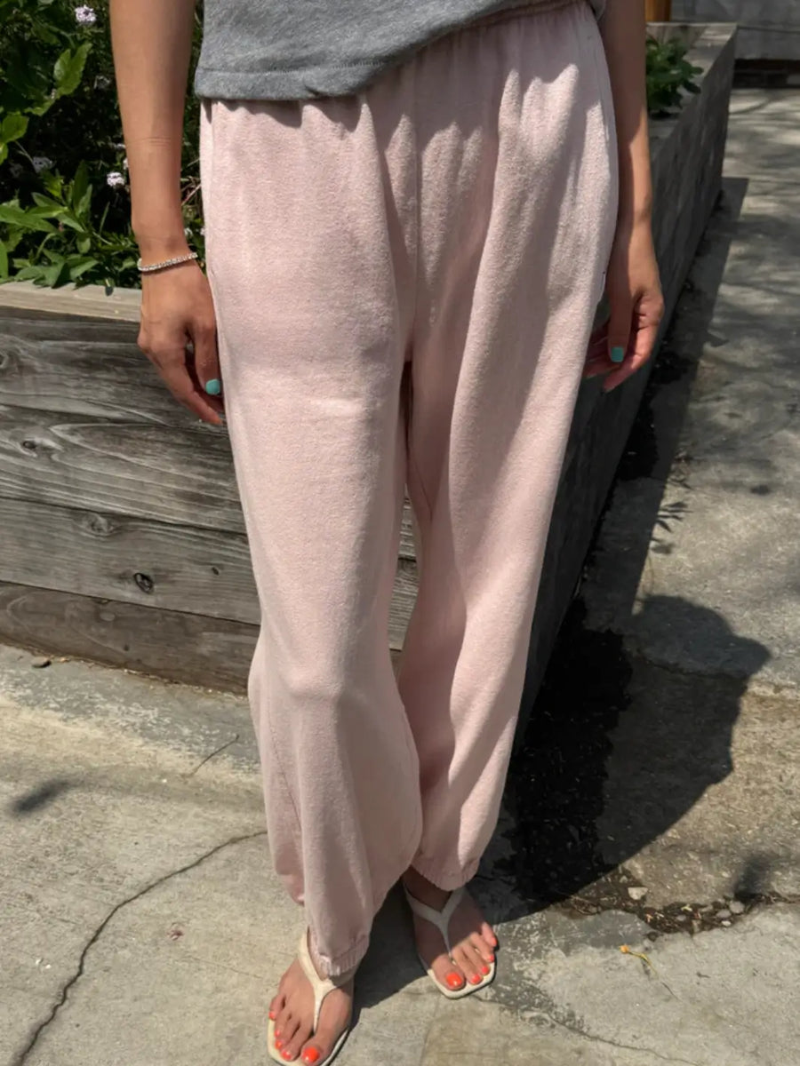 A person models the high-waisted, relaxed-fit Le Bon Shoppe Balloon Pants in Baby Pink with an elastic waistband and cuffs while standing outdoors | Twentyseven Toronto