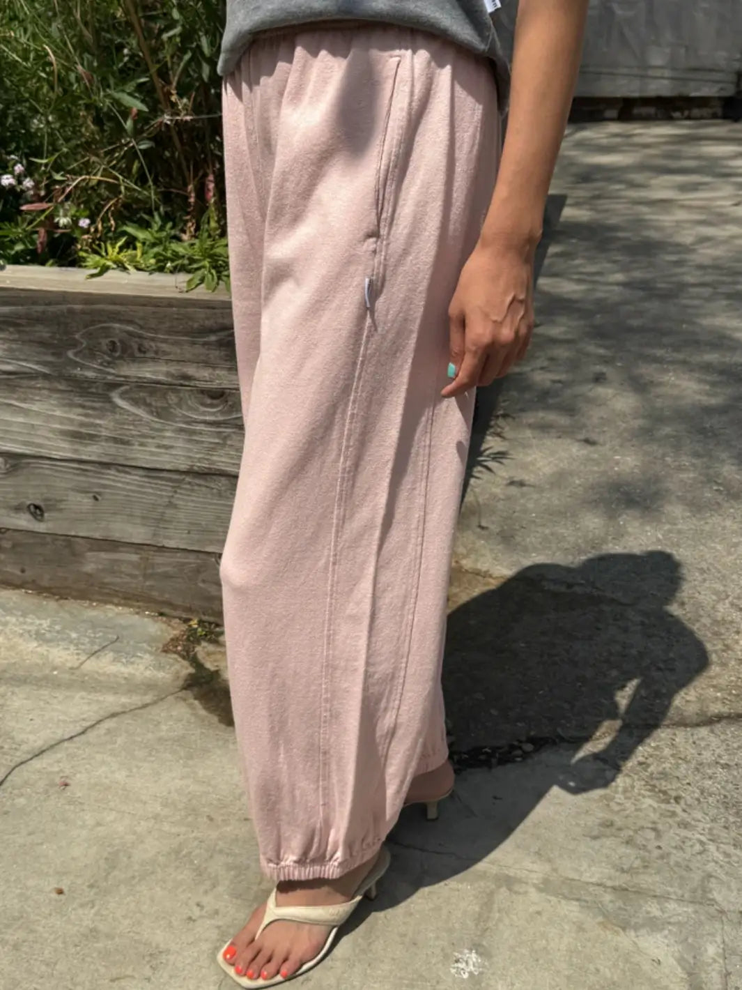A side view captures a person wearing the wide-leg Le Bon Shoppe Balloon Pants in Baby Pink, featuring vertical seam details and side pockets | Twentyseven Toronto