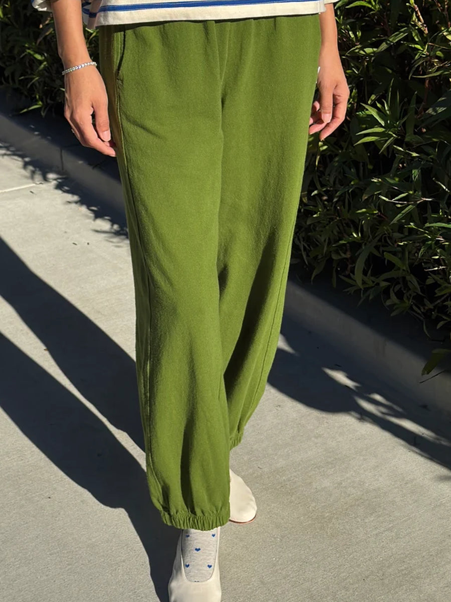 Front view of Collard Green Balloon Pants featuring a relaxed, voluminous fit and elasticated ankle cuffs, styled with a blue and white striped top and cream heels | Twentyseven Toronto