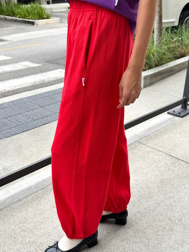 Model wearing red balloon pants with an elastic waist and relaxed wide-leg fit | Twentyseven Toronto