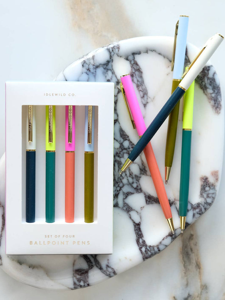 Idlewild Co. Tokyo City Palette Pens displayed in their white gift box alongside four colourful ballpoint pens arranged on a marble tray | Twentyseven Toronto