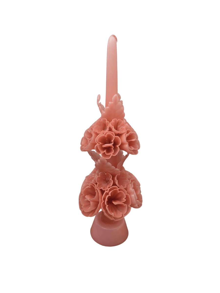 An pink hand-carved Banderilla Scaled Candle in Dusty Rose from Cereria de Jesus features two tiers of intricate wax flowers wrapped around a central taper stem | Twentyseven Toronto