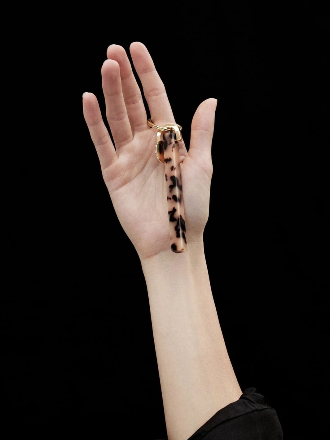 Hand holding keychain with tortoiseshell design and gold clasp from MACHETE | Twentyseven Toronto