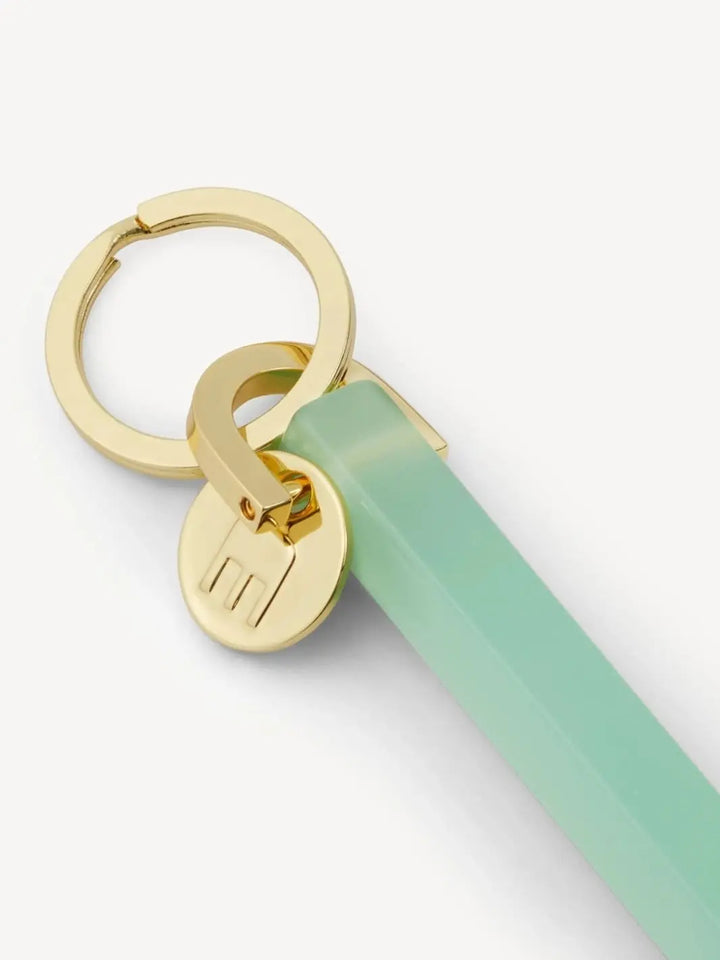 Gold and light green keychain from MACHETE | Twentyseven Toronto