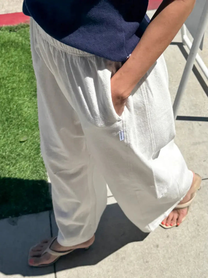 A close-up side view highlights a model resting their hand in the deep side pocket of the relaxed-fit Le Bon Shoppe Bare Pants in White Cotton | Twentyseven Toronto