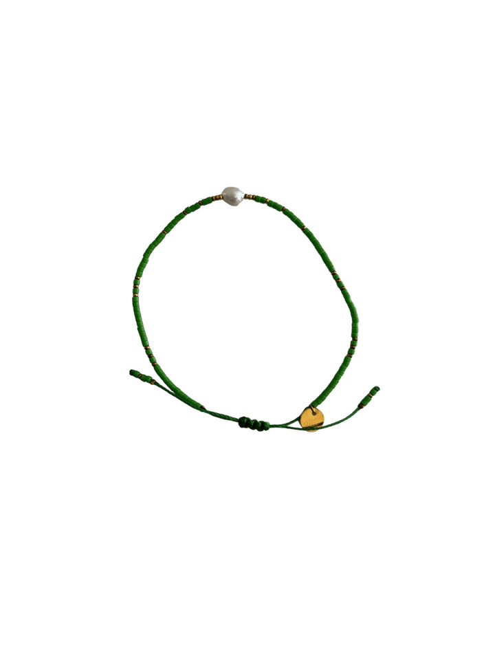 Bracelet with green cord, green and gold beads and single white pearl with gold charm on a transparent background | Twentyseven Toronto