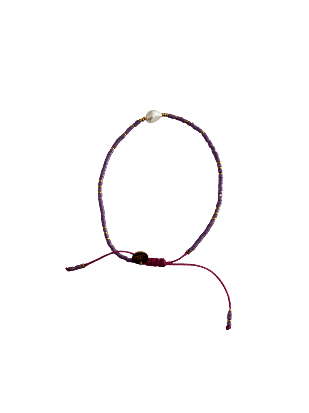 Bracelet with purple cord, small purple and gold beads and single white pearl with gold charm on a transparent background | Twentyseven Toronto