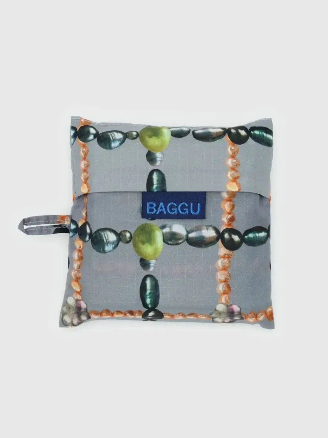 The Baggu Beaded Plaid Bag is neatly folded into its matching square pouch, displaying the distinct beaded pattern and a dark blue BAGGU logo tab | Twentyseven Toronto