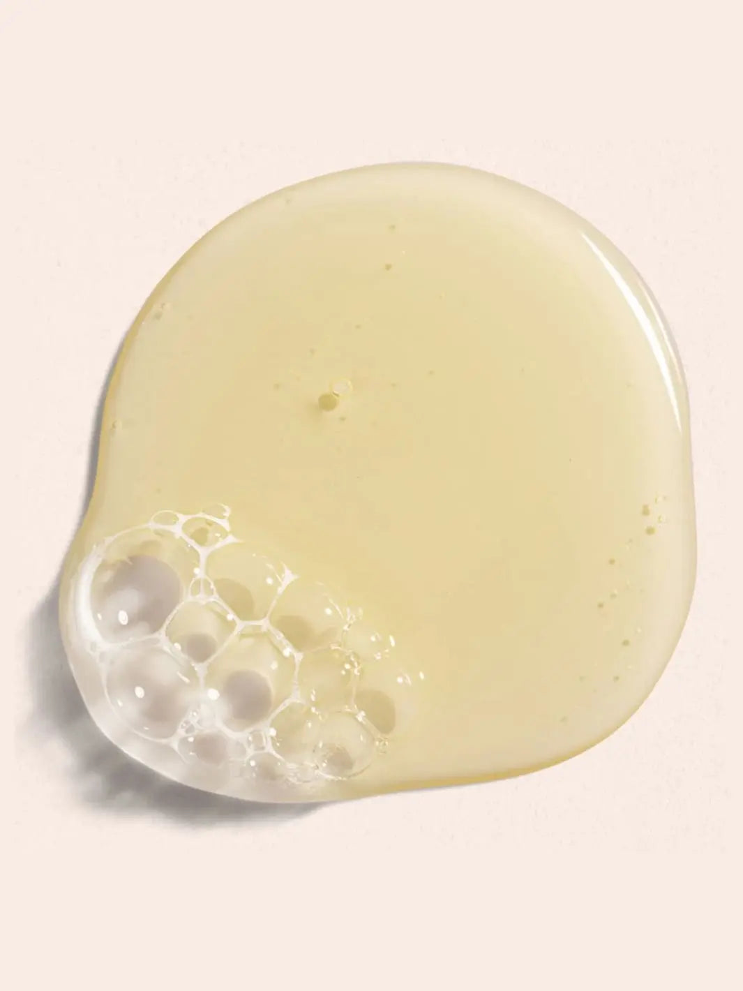 Beauty from Bees Body Wash | Twentyseven Toronto | Close-up of a dollop of Beauty from Bees Body Wash with bubbles on a light pink background