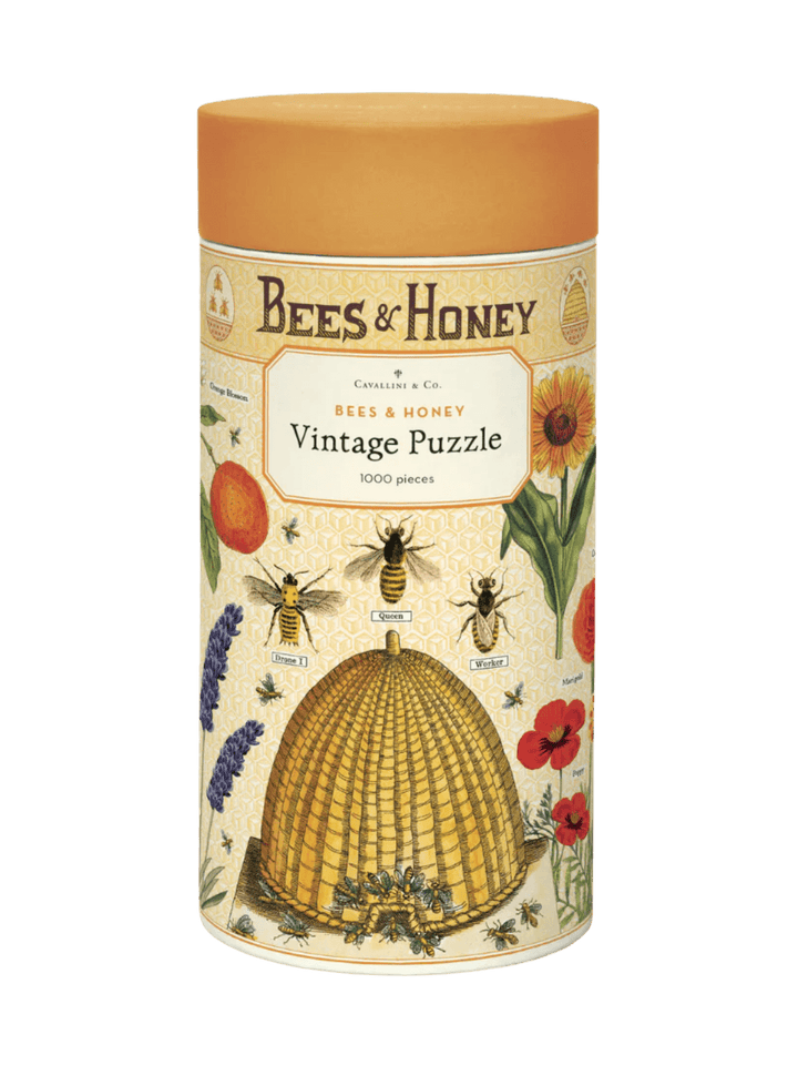 A cylindrical cardboard puzzle tube featuring an orange cap and vintage bee illustrations for the Cavallini Paper & Co Bees & Honey 1000 Piece Puzzle | Twentyseven Toronto