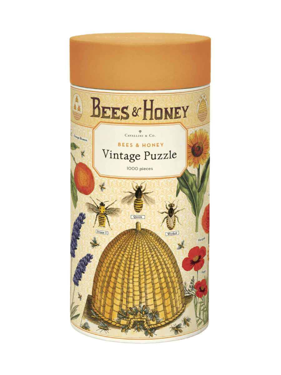 A cylindrical cardboard puzzle tube featuring an orange cap and vintage bee illustrations for the Cavallini Paper & Co Bees & Honey 1000 Piece Puzzle | Twentyseven Toronto