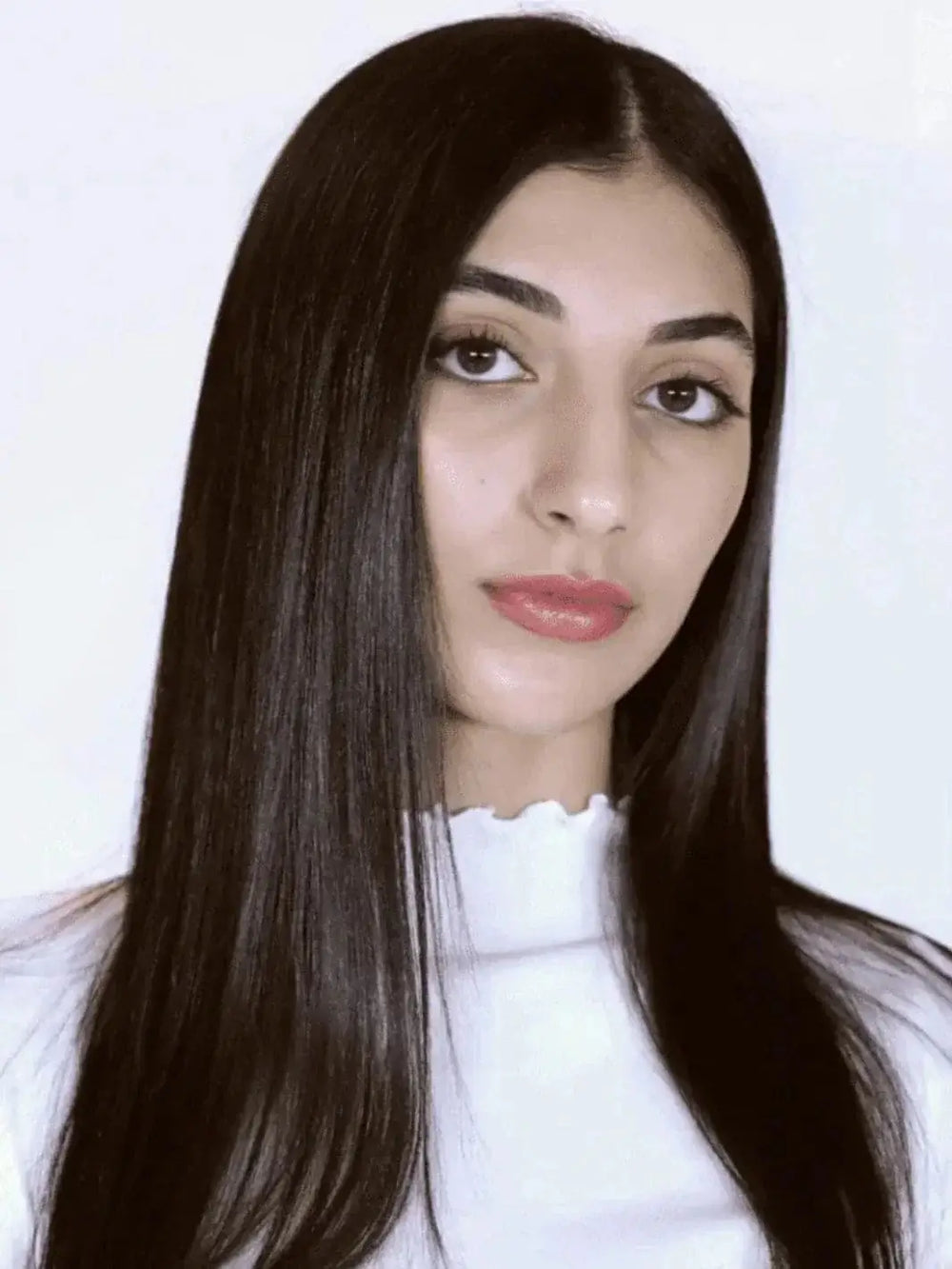 A model with long, sleek, and straight dark hair showcases a smooth and glossy finish after using R+Co BEL AIR Smoothing + Anti-Oxidant Complex Shampoo | Twentyseven Toronto