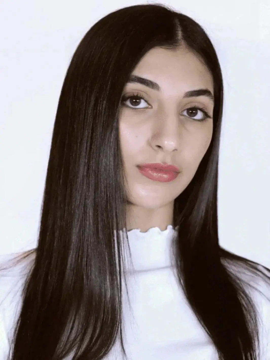 A model with long, sleek, and straight dark hair showcases a smooth and glossy finish after using R+Co BEL AIR Smoothing + Anti-Oxidant Complex Shampoo | Twentyseven Toronto