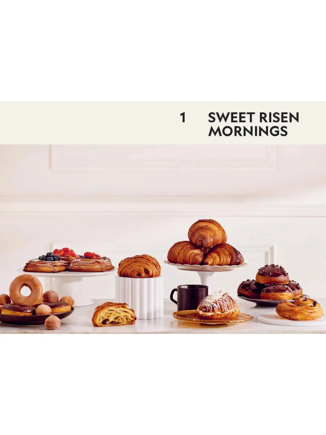 Spread titled "Sweet Risen Mornings" from Beyond Baking: Plant-Based Baking for a New Era by Philip Khoury, showcasing an assortment of plant-based pastries, including croissants, danishes, and doughnuts | Twentyseven Toronto