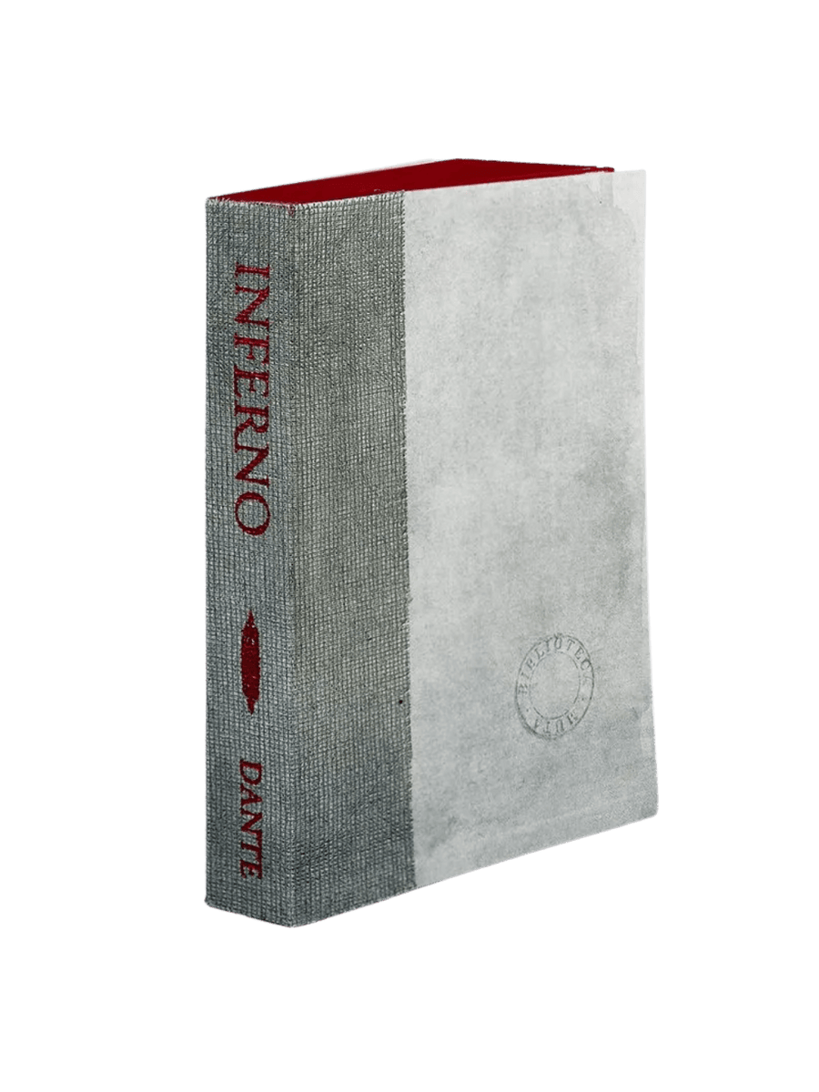 A notebook of Inferno from the Slow Design Biblioteca Muta collection features a textured grey gauze spine stamped with deep red literary typography alongside a pale parchment-style cover bearing a circular library seal | Twentyseven Toronto