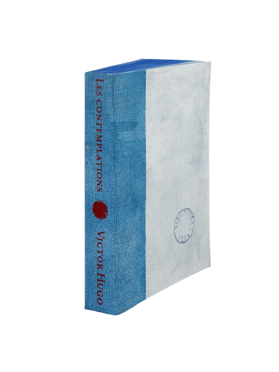 A notebook from the Les Contemplations from the Slow Design Biblioteca Muta collection features a textured light blue gauze spine stamped with red literary typography next to a pale cover bearing a circular library seal | Twentyseven Toronto