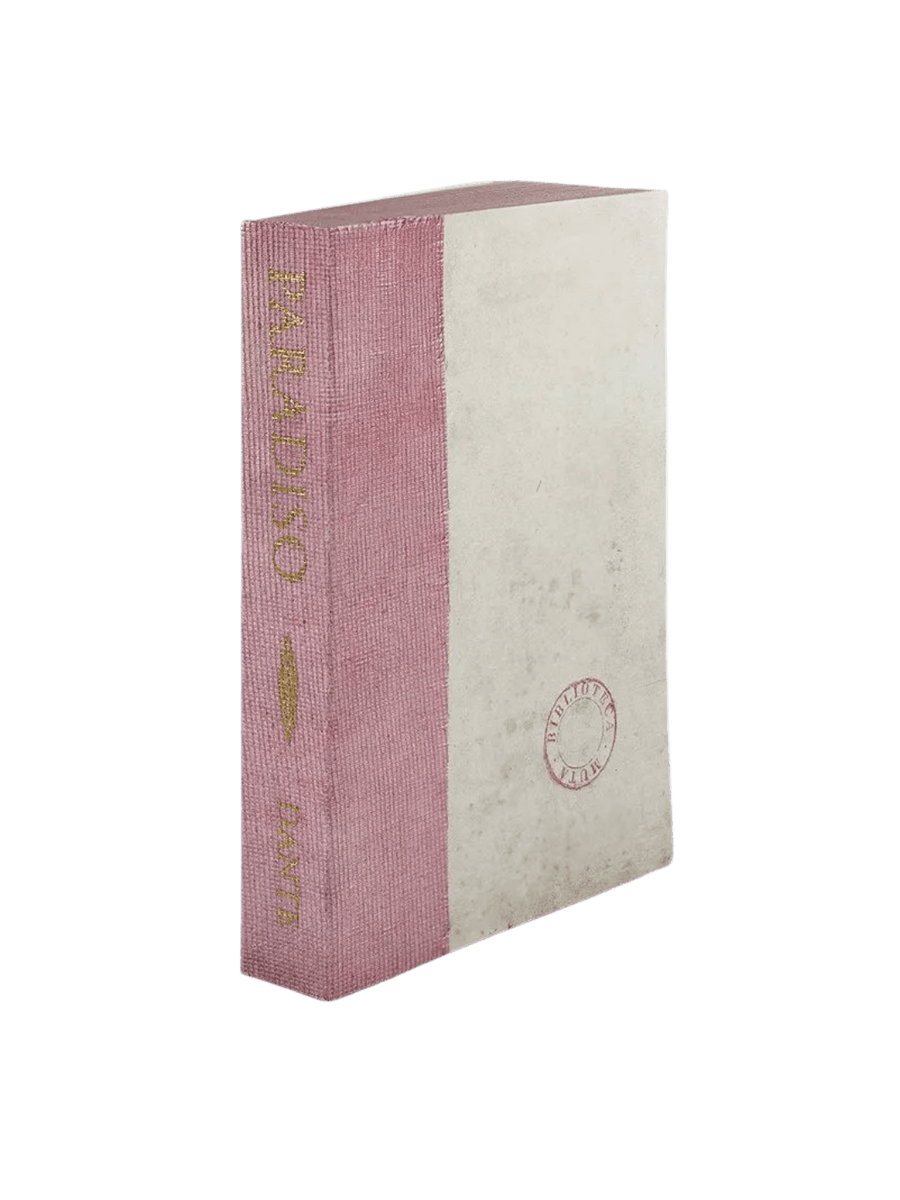 A notebook of Paradiso from the Slow Design Biblioteca Muta collection features a textured lavender-pink gauze spine stamped with elegant gold literary typography alongside a pale parchment-style cover bearing a circular library seal | Twentyseven Toronto