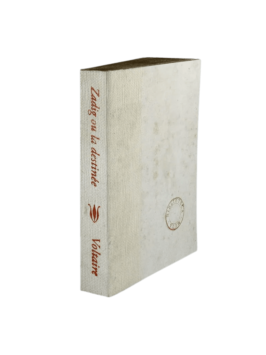 A notebook of Zadig ou la destinée from the Slow Design Biblioteca Muta collection features an off-white textured gauze spine stamped with elegant brown typography and a matching pale cover detailing a circular library seal | Twentyseven Toronto