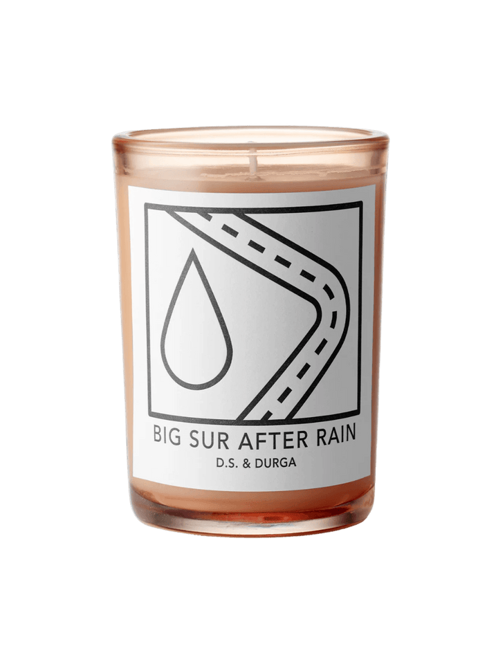 DS&Durga candle in an orange glass jar labeled 'Big Sur After Rain' featuring a raindrop and road designs on a transparent background | Twentyseven Toronto