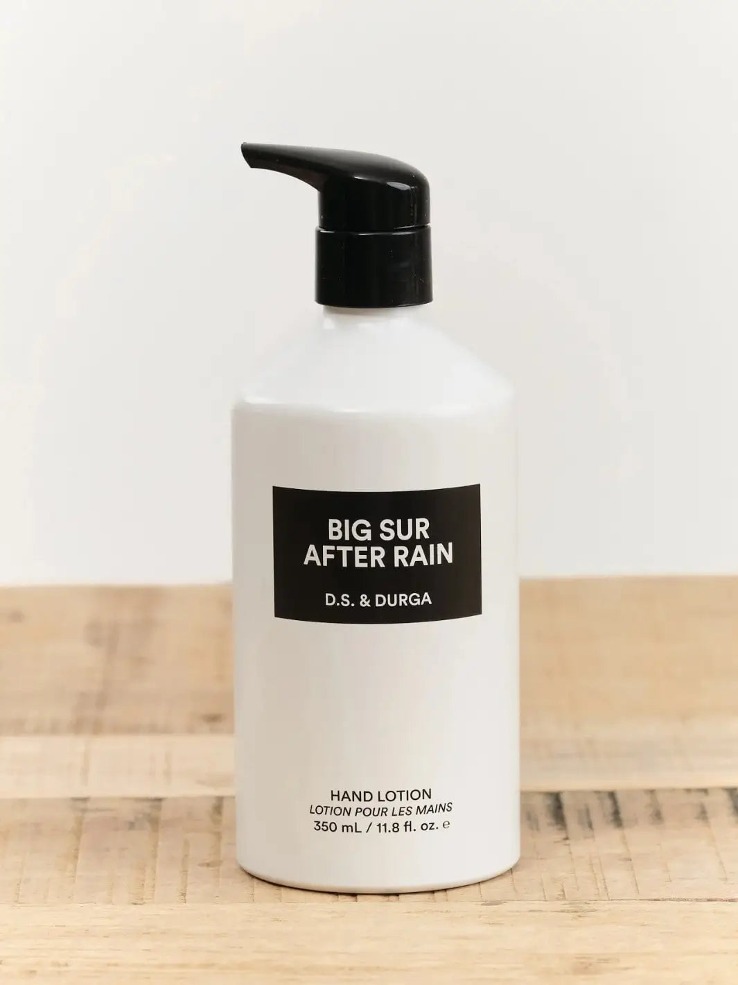 Hand lotion 350ml bottle labeled 'Big Sur After Rain' by D.S. & Durga on a wooden surface with a white background | Twentyseven Toronto