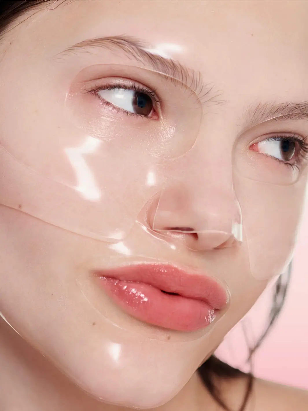 A detailed close-up shot captures the clear, gel-like texture of the Biodance Bio - Collagen Real Deep Mask as it adheres seamlessly to a woman's face after absorbing into her skin | Twentyseven Toronto