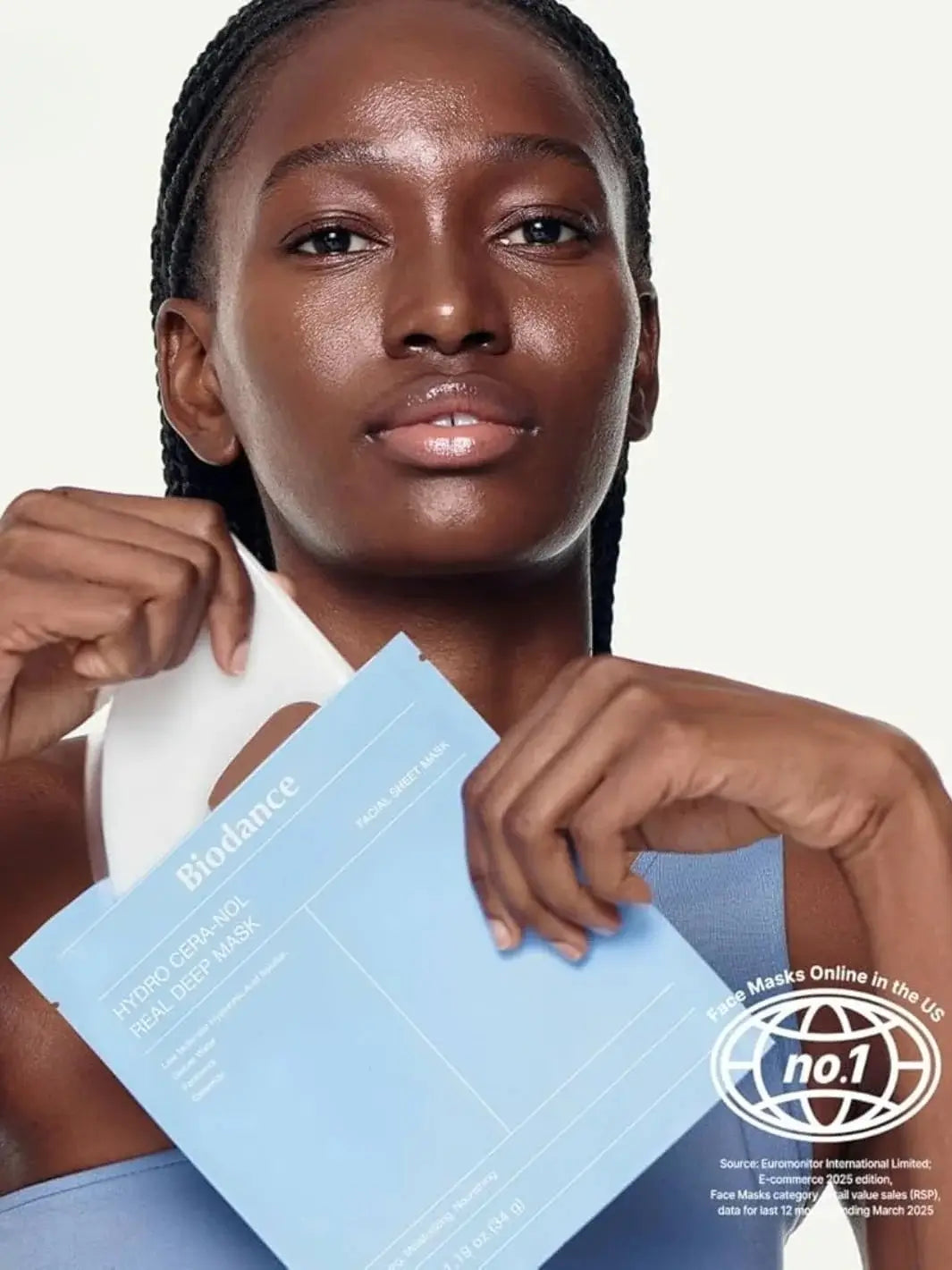 A close-up shot of a woman pulling a white hydrogel mask out of a light blue packaging labeled Biodance Hydro Cera-nol Real Deep Sheet Mask | Twentyseven Toronto