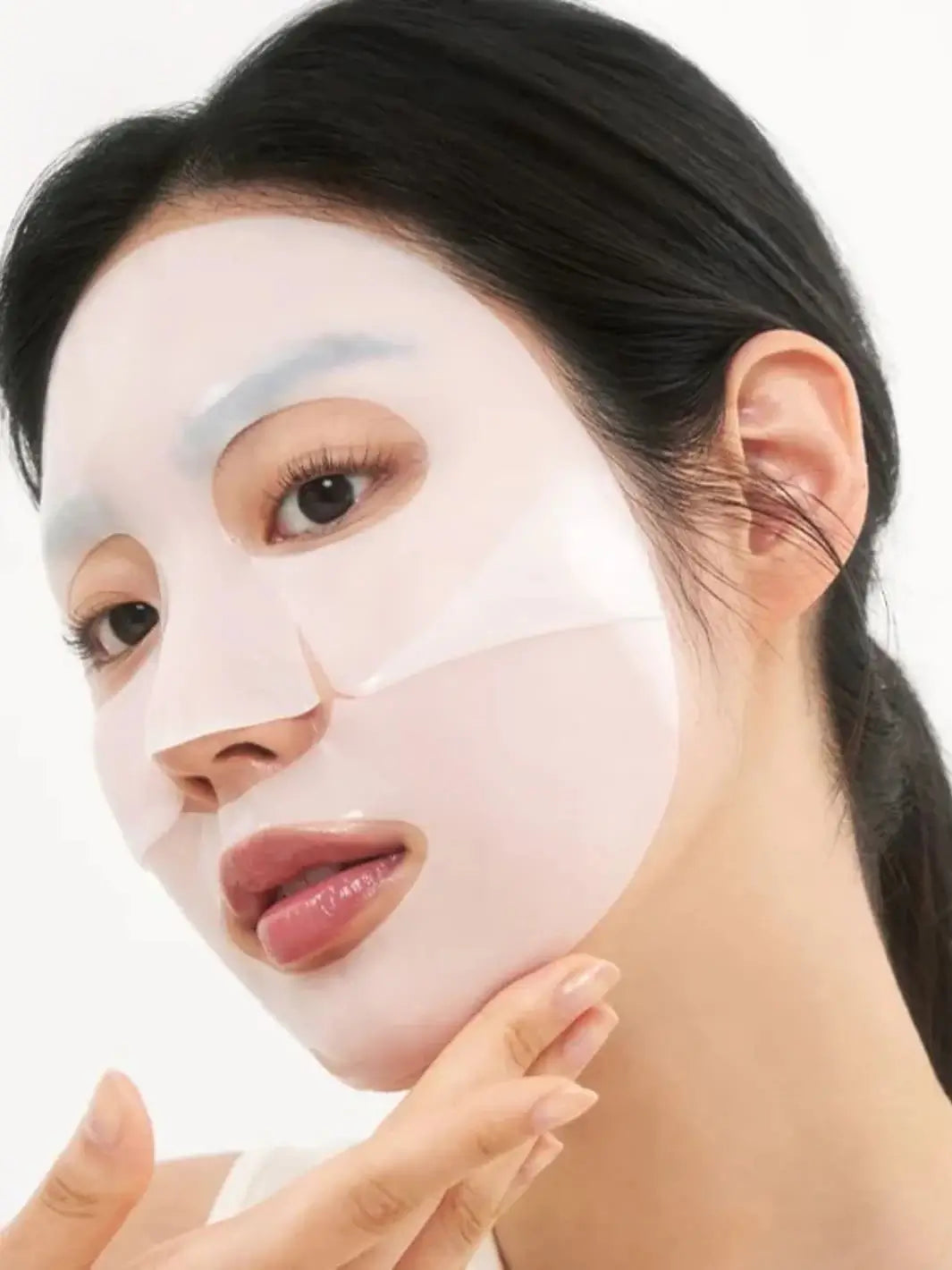 A woman wearing an opaque, white hydrogel Biodance Hydro Cera-nol Real Deep Sheet Mask on her face | Twentyseven Toronto