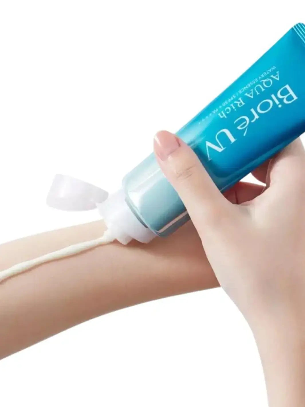 Hand holding Biore UV Aqua Rich Watery Essence SPF50+ PA++++ blue sunscreen tube dispensing product on arm | Twentyseven Toronto