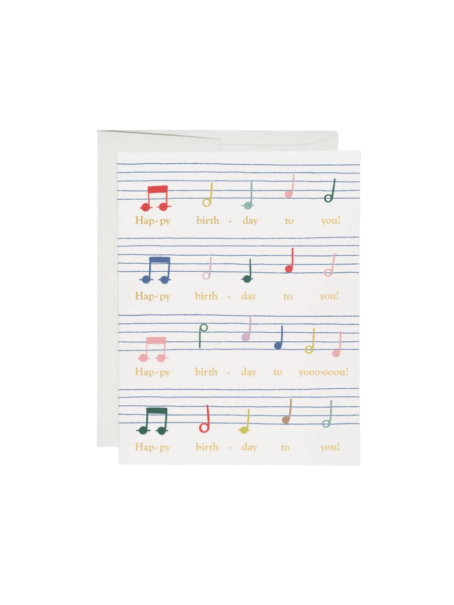 A Birthday Song Greeting Card by The House That Lars Built features a colorful illustration of sheet music lines and notes corresponding to the lyrics "Happy birthday to you," shown next to a white envelope | Twentyseven Toronto