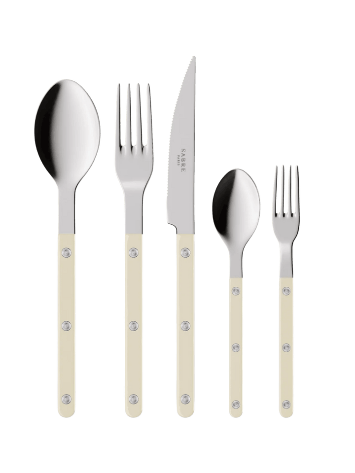 The complete Sabre Paris Bistrot Solid Shiny 5 Piece Cutlery Set in Ivory including a soup spoon, a dinner fork, a serrated dinner knife blade, a teaspoon and a small fork | Twentyseven Toronto