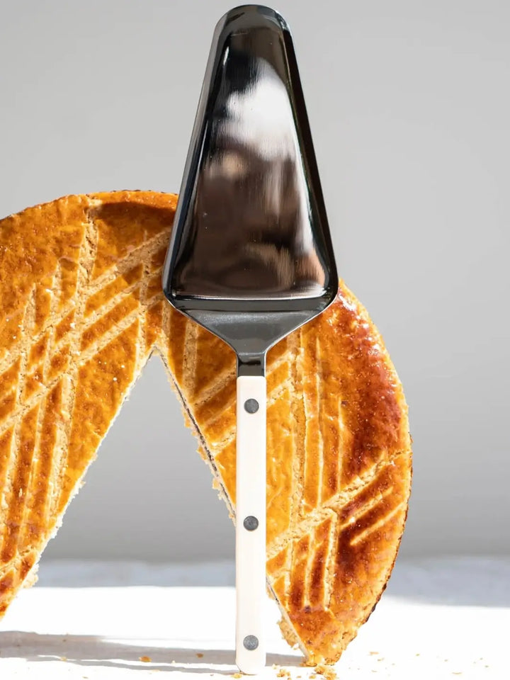 Sabre Paris Bistrot Solid Shiny Tart Server in Ivory stands upright in the center of a sliced golden-brown tart | Twentyseven Toronto
