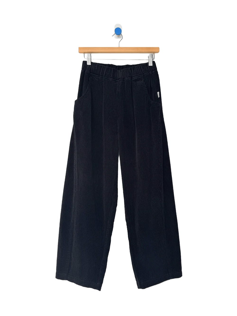 Le Bon Shoppe Soft Corduroy Arc Pants in Black on wooden hanger, front view | Twentyseven Toronto