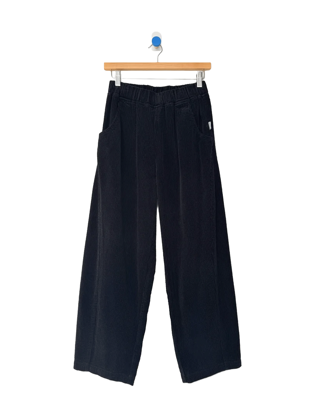 Le Bon Shoppe Soft Corduroy Arc Pants in Black on wooden hanger, front view | Twentyseven Toronto