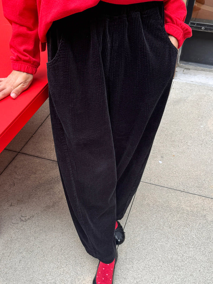 Le Bon Shoppe Soft Corduroy Arc Pants in Black worn outdoors, front view showing elastic waist and deep pockets | Twentyseven Toronto