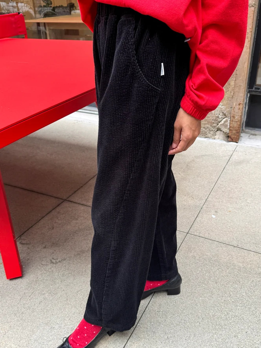Le Bon Shoppe Soft Corduroy Arc Pants in Black worn outdoors, side view showing curved leg and pocket | Twentyseven Toronto
