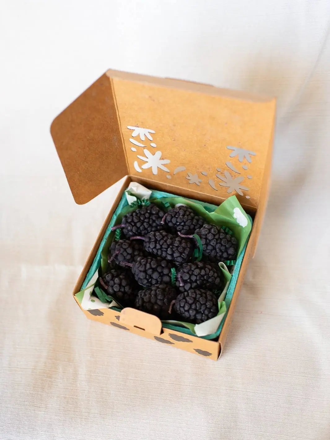 Box of blackberry shaped candles from Happy Organics in brown packaging on a white background | Twentyseven Toronto