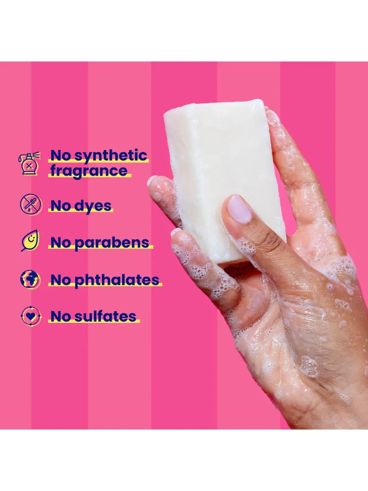 Hand holding a 'Blade Bar' soap from Megababe with a pink background and text about product ingredients | Twentyseven Toronto