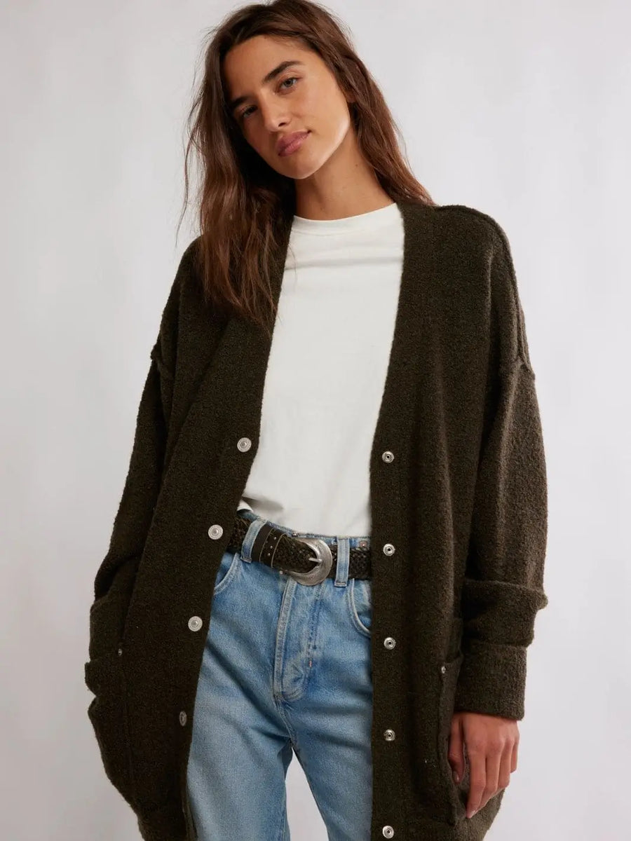 A studio portrait shows a model wearing the open, oversized Free People Blazing Cardi in Dark Green layered over a white t-shirt and light wash jeans | Twentyseven Toronto