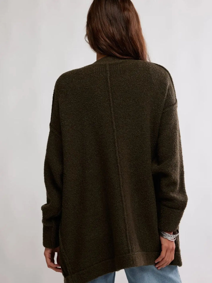 A rear view captures the dropped shoulders and clean center-back seam detailing of the longline Free People Blazing Cardi in Dark Green | Twentyseven Toronto