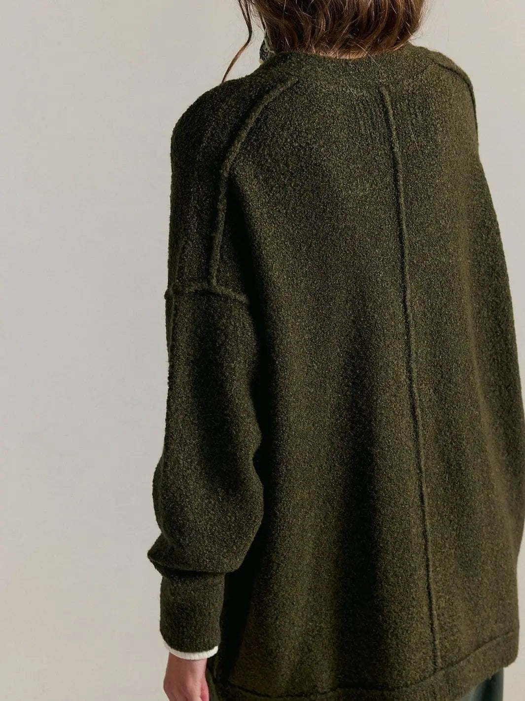 A close-up three-quarter back view emphasizes the soft, plush knit texture and slouchy silhouette of the Free People Blazing Cardi in Dark Green | Twentyseven Toronto