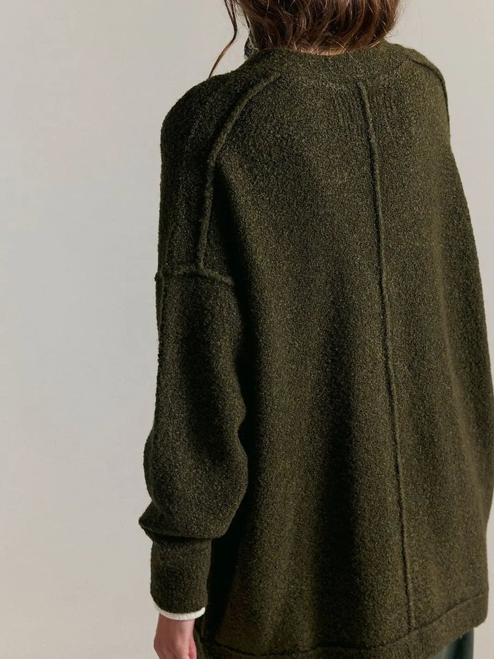A close-up three-quarter back view emphasizes the soft, plush knit texture and slouchy silhouette of the Free People Blazing Cardi in Dark Green | Twentyseven Toronto