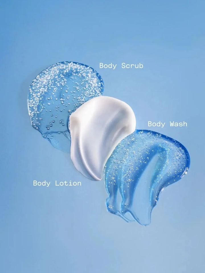 Textures of textured body scrub, clear body wash, and creamy white Dedcool Body Lotion 01 "Taunt" are swatched together against a solid light blue background | Twentyseven Toronto