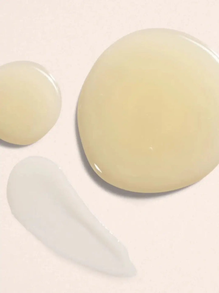 A close-up view showing liquid drops and a creamy swatch of the Beauty from Bees Body Serum in Lime Obsession formula against a light neutral background | Twentyseven