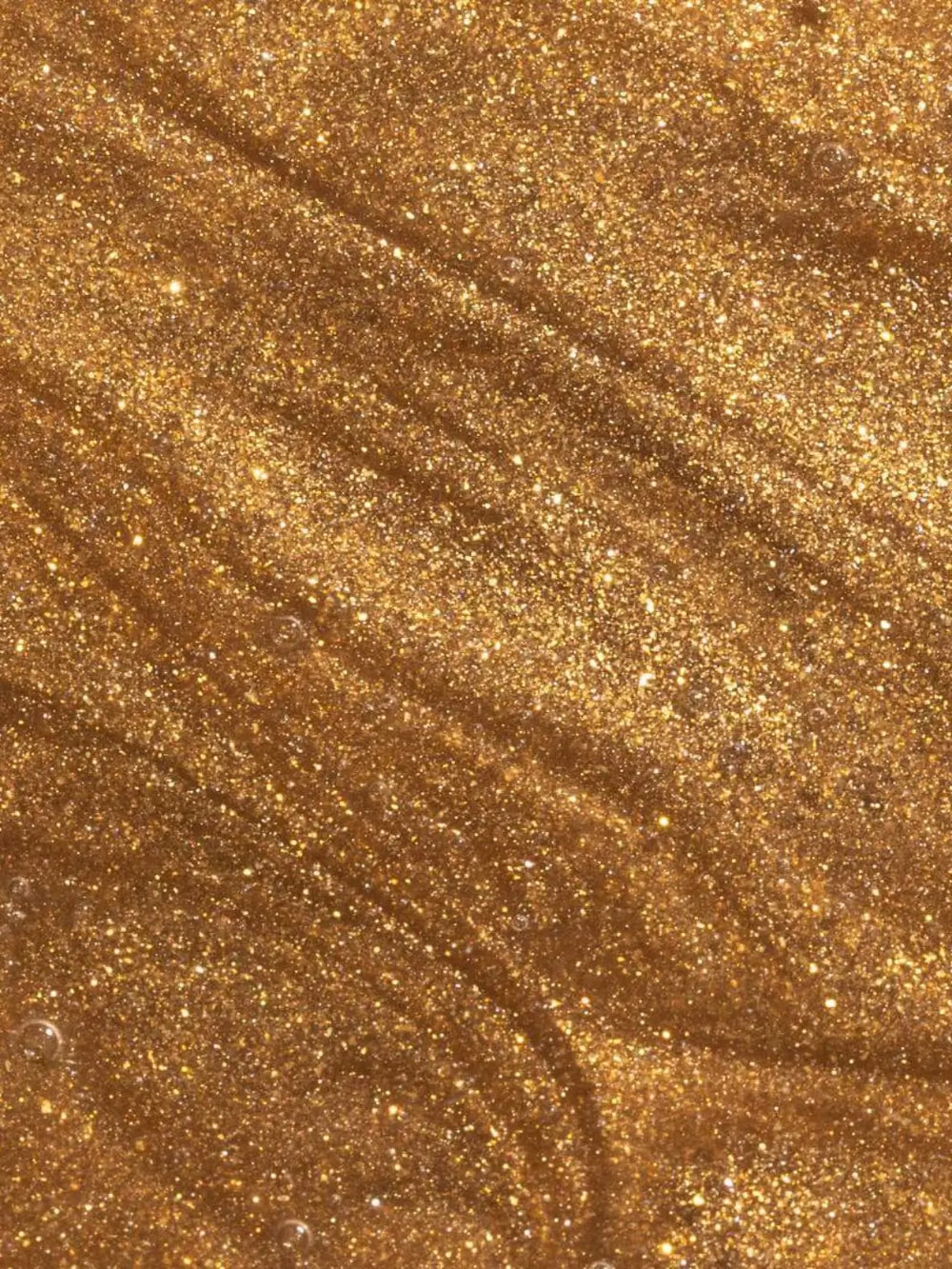 Close-up view shows the shimmering, golden glitter texture of the liquid Beauty from Bees Body Serum - Summer Glow | Twentyseven Toronto