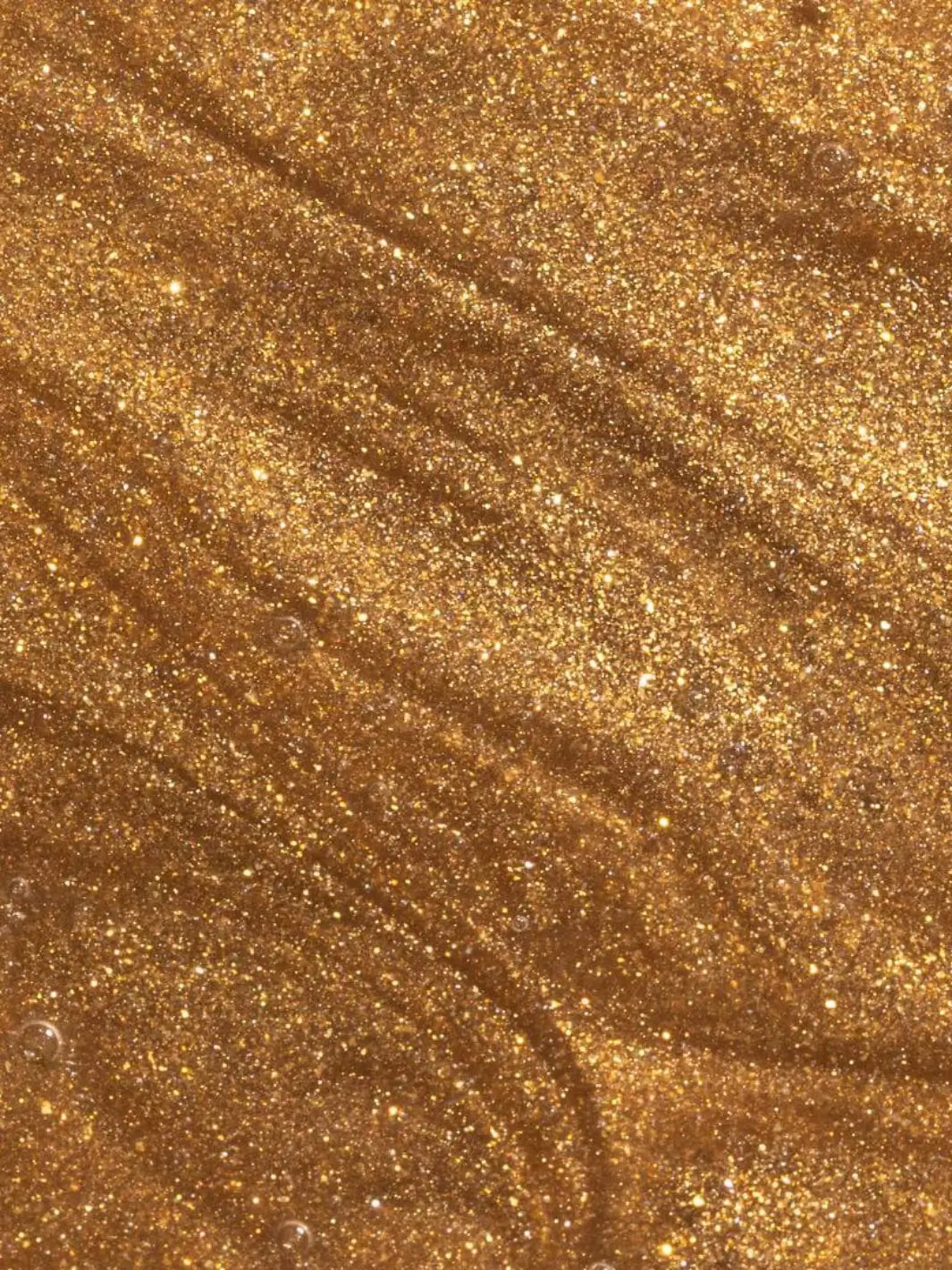 Close-up view shows the shimmering, golden glitter texture of the liquid Beauty from Bees Body Serum - Summer Glow | Twentyseven Toronto