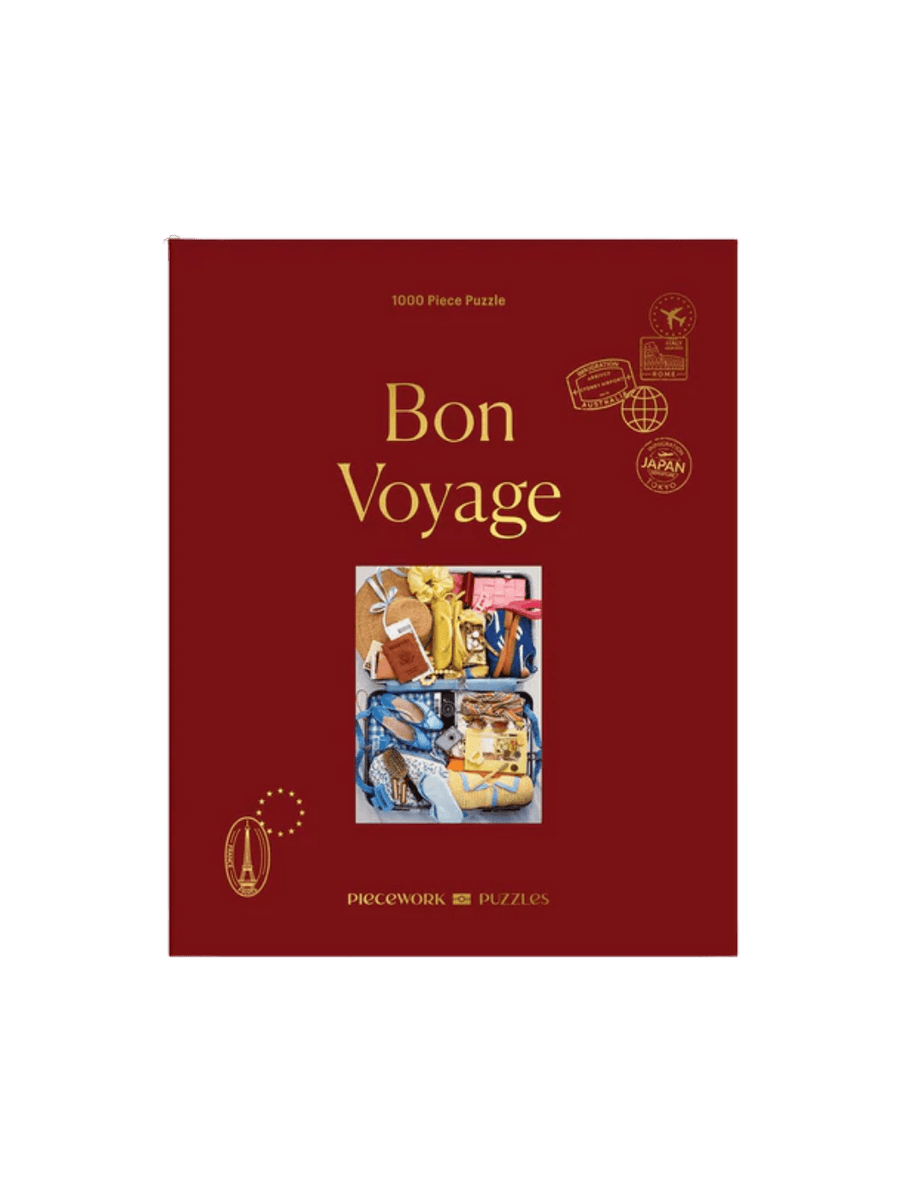 The Piecework Puzzles Bon Voyage 1000 Piece Puzzle features its classic dark red box cover | Twentyseven Toronto