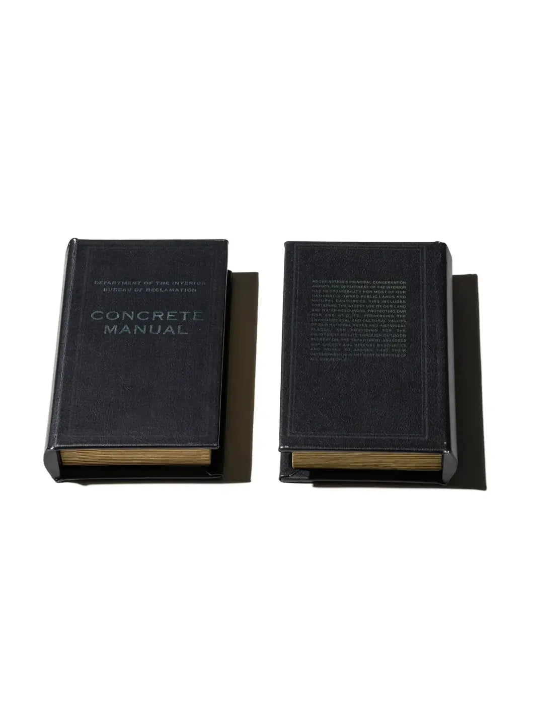 Both the front and back covers of the Book Box - Concrete Manual BK from Puebco are laid flat, showcasing the industrial aesthetic and precise debossed typography | Twentyseven Toronto