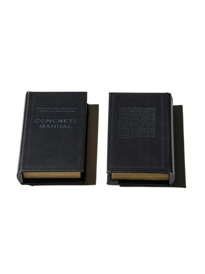 Both the front and back covers of the Book Box - Concrete Manual BK from Puebco are laid flat, showcasing the industrial aesthetic and precise debossed typography | Twentyseven Toronto